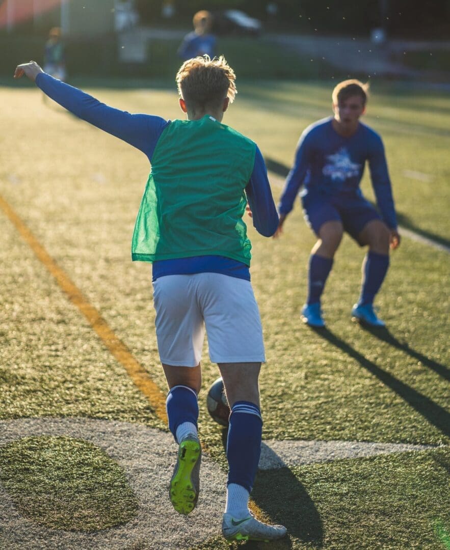 Two young men playing soccer on a field.