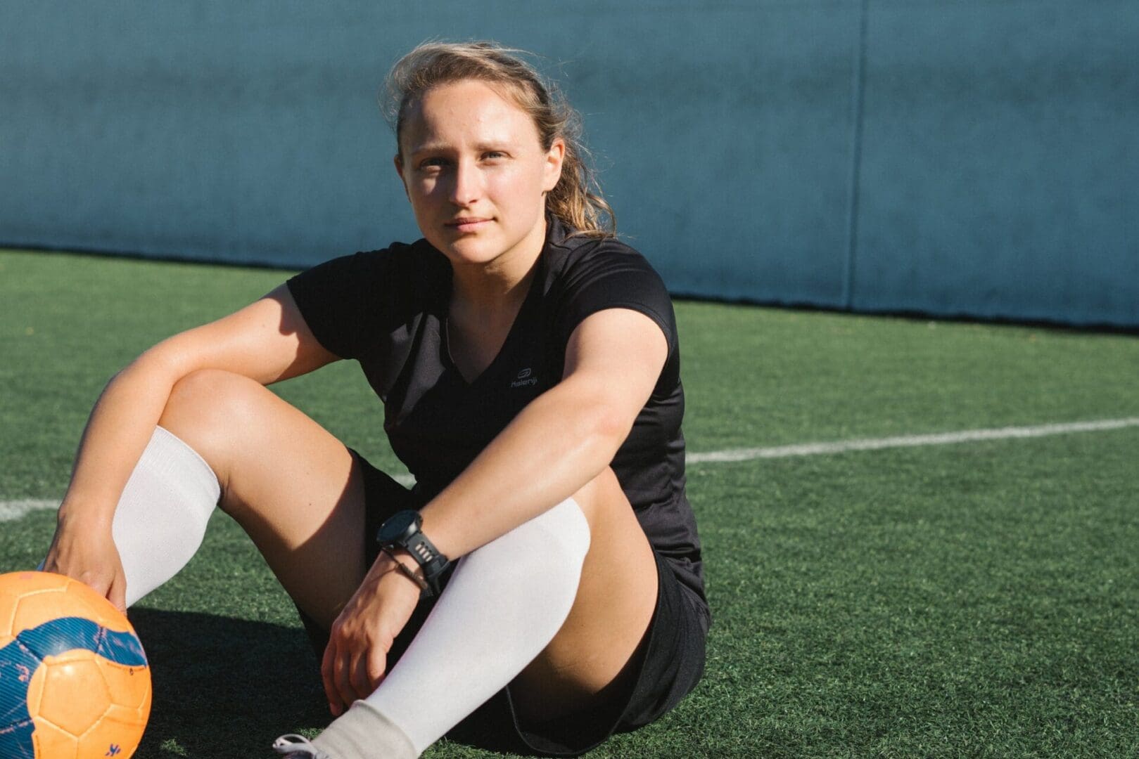 A woman sitting on the ground with her legs crossed.